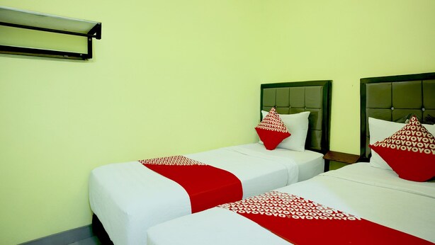 A hotel room with two beds, each with a red and white patterned pillow and a white bedspread. - Cozy Twin Escape With Free Wifi and Parking (Parapat)