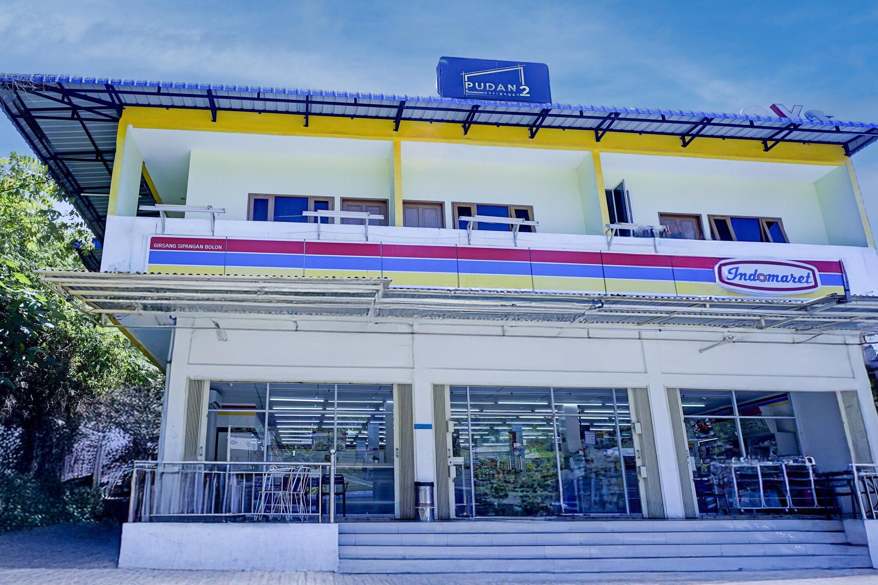 A two-story building with a sign for 'PUDAN 2' and 'Indomaret' indicating a supermarket.