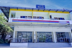 Um edifício de dois andares com uma placa indicando 'PUDAN 2' e 'Indomaret', sinalizando um supermercado.