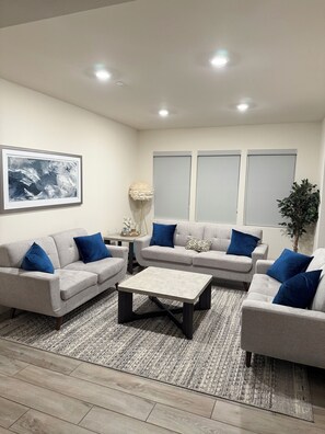 A modern living room with a grey sofa set, a coffee table, and a patterned rug. - NEW LUXURY LISTING - spacious luxurious 4-bedroom house in Tracy with wifi & AC (Tracy)