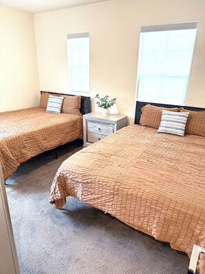 A room with two beds, a nightstand, a potted plant, and a window. - NEW LUXURY LISTING - spacious luxurious 4-bedroom house in Tracy with wifi & AC (Tracy)