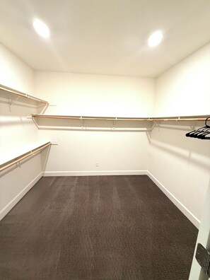 A walk-in closet with a grey carpet, white walls, and wooden shelves. - NEW LUXURY LISTING - spacious luxurious 4-bedroom house in Tracy with wifi & AC (Tracy)