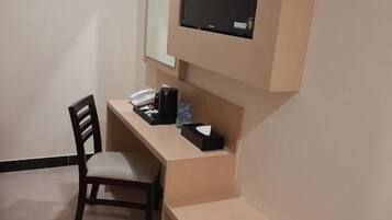 Una habitación pequeña con un escritorio, una silla y un televisor de pantalla plana montado en la pared.