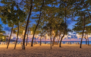 A beach with trees and tables set up for dining, overlooking the sea. - TITLE Serenity by TVC (Sakhu)