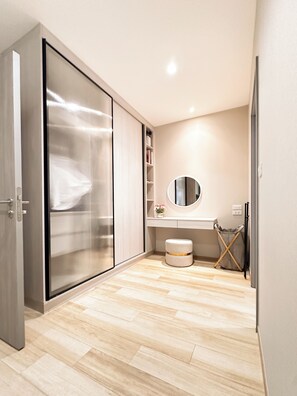 A modern bathroom with a sliding door, a round mirror, and a wooden floor.