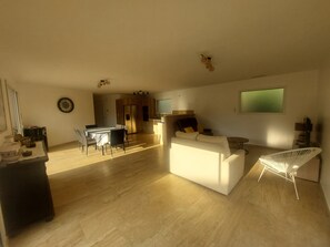 A spacious living area with a dining table, sofas, and a kitchen in the background. - New Listing: A recently built, air-conditioned home at a very affordable price! Close to the sea and the mountains (Saint-André)