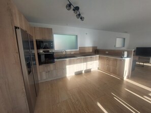 A modern kitchen with wooden cabinets, a built-in oven, and a large window. - New Listing: A recently built, air-conditioned home at a very affordable price! Close to the sea and the mountains (Saint-André)