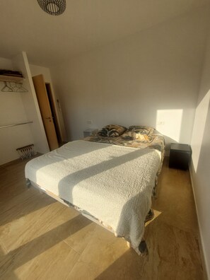 A bedroom with a bed, a radiator, a wardrobe, and a door. - New Listing: A recently built, air-conditioned home at a very affordable price! Close to the sea and the mountains (Saint-André)