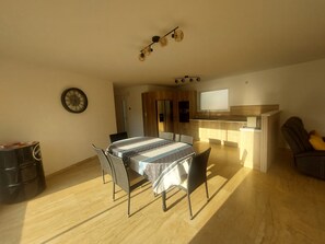 A compact living space with a dining area, kitchenette, and a clock on the wall. - New Listing: A recently built, air-conditioned home at a very affordable price! Close to the sea and the mountains (Saint-André)