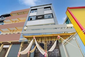 A multi-story building with a sign indicating it is a serviced apartment complex.