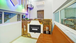 Un interior moderno con una recepción que indica 'TOWNHOUSE Company Serviced', una escalera y un gran ventanal con vistas.