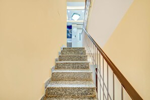 A staircase with a handrail and a light-colored wall. - Super Townhouse Anisabad Near Mahavir (Patna)