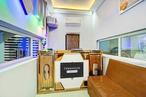 A modern interior with a reception desk labeled 'TOWNHOUSE' and a leather couch.