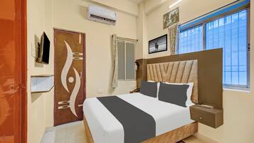 Une chambre d’hôtel avec un grand lit, une fenêtre offrant une belle vue, une porte au design original et un appareil de climatisation.