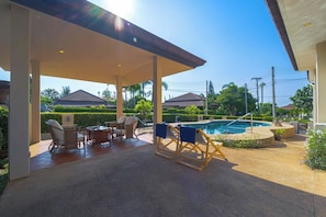 A covered outdoor area with a pool, lounge chairs, and a table. - Stylish3BR PoolVilla,Prime Location-H146 (Hua Hin)
