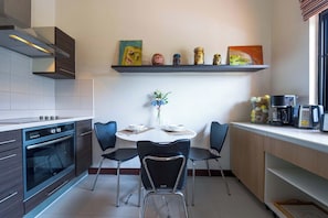 A modern kitchen with a dining table, chairs, and a coffee machine. - Stylish3BR PoolVilla,Prime Location-H146 (Hua Hin)