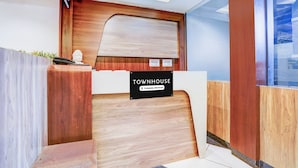 En receptionsdisk med en skylt som visar texten: ”TOWNHOUSE – företagstjänster”.