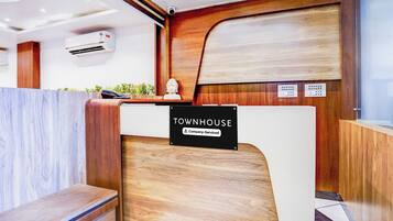 A reception desk with a sign reading 'TOWNHOUSE Company-Serviced' and a wooden reception area.