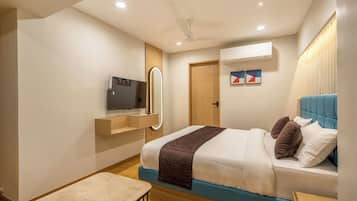 A modern bedroom with a bed, bedside table, mirror, and a ceiling fan.