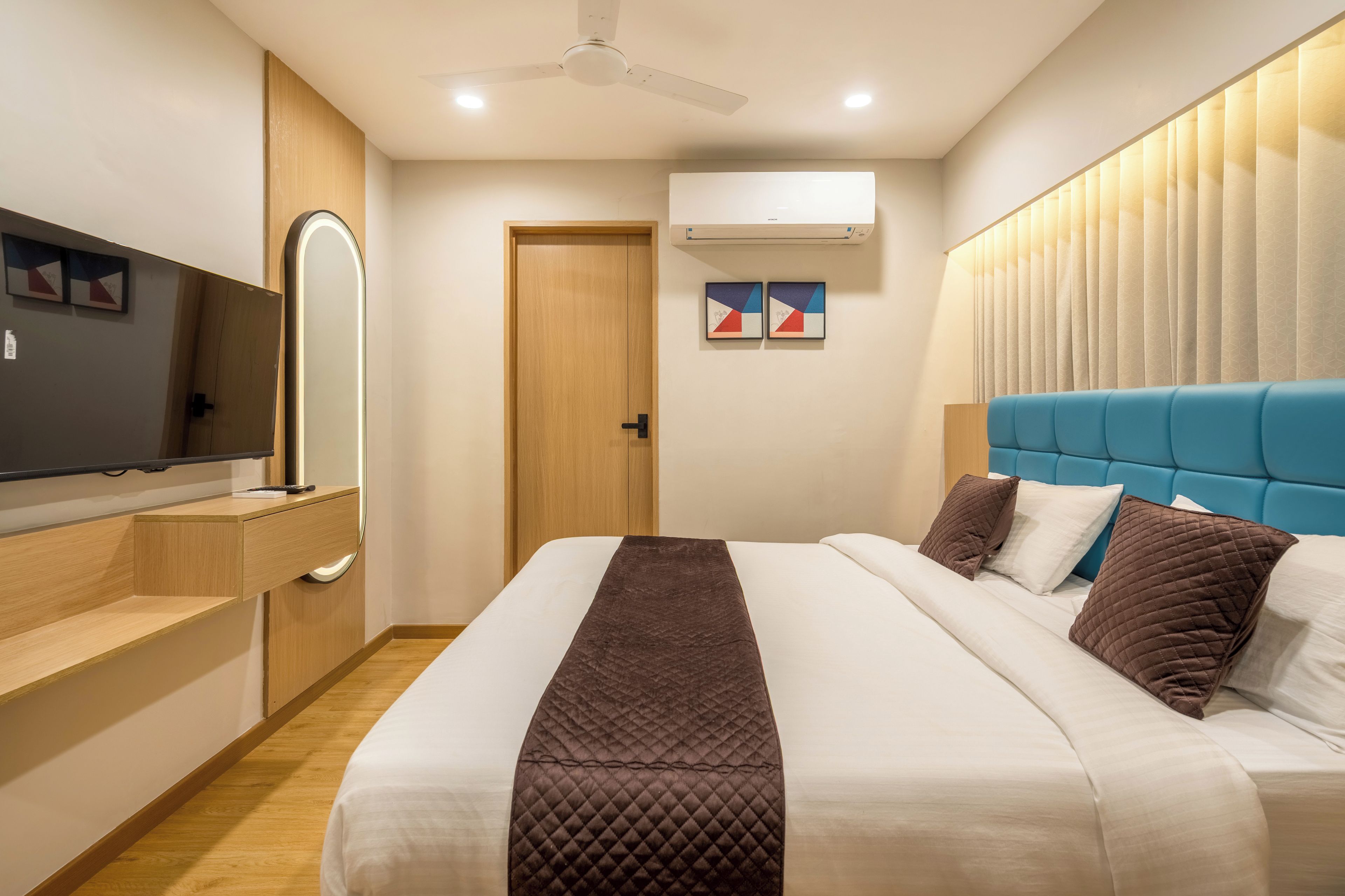 Une chambre d’hôtel moderne équipée d’un lit, d’une télévision, d’une armoire et d’un appareil de climatisation.