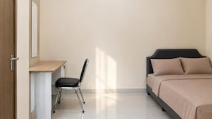 Quarto com cama, escrivaninha e cadeira.