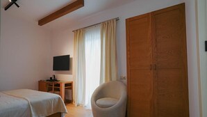 A bedroom with a bed, a chair, a TV, and a wardrobe. - Mikheilis Marani Boutique Hotel  (Kvareli)