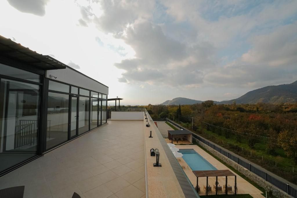 Terraço no telhado com piscina, área de estar ao ar livre e vista para as montanhas.