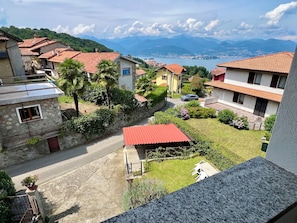 A residential area with houses, a paved road, and a view of distant mountains.