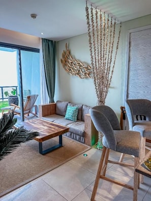 A modern living room with a sofa, chairs, a coffee table, and a decorative wall piece.