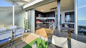 A modern kitchen with a built-in oven, a washing machine, and a dining area with a table and chairs. - "Horizon Bleu" One-bedroom apartment with balcony, ocean view, pool, and parking (Cap-d'Ail)
