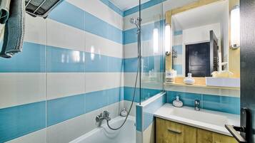A bathroom with a shower, a bathtub, and a vanity with a mirror.