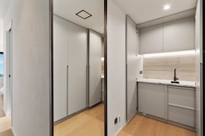 Eine moderne Küche mit grauen Schränken, einer weißen Arbeitsplatte und einer eingebauten Spüle.