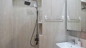A modern bathroom with a shower, a sink, and a mirror. - OCEANSUITE (Busan)