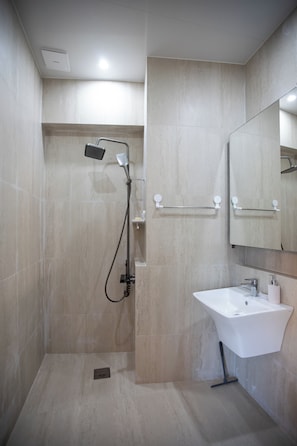 A modern bathroom with a shower, a sink, and a mirror. - OCEANSUITE (Busan)
