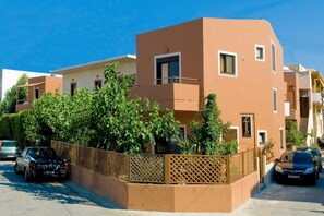 Ein modernes Mehrfamilienhaus mit Balkonen, einem verschlossenen Eingang und geparkten Autos.
