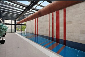 Bright indoor lap pool with sleek design and year-round swim access - On the Boulevard - Styled 1BR with Views (Melbourne)