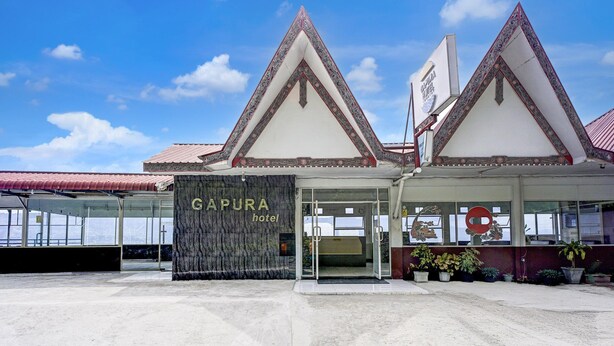 A hotel entrance with a sign reading 'CAPURA hotel' and a traditional architectural style with pointed roofs.