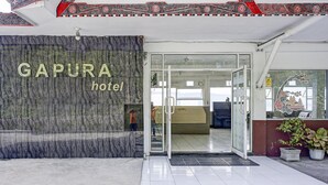 The entrance to GAPURA hotel with a marble facade and a reception area visible inside.