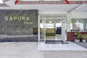The entrance to GAPURA hotel with a marble facade and a reception area visible inside.