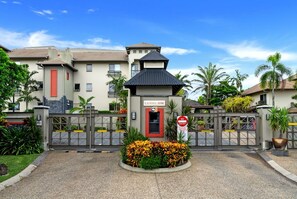 A gated entrance to a residential building with a sign reading 'CAIRNS ONE.' - Belle Escapes Cairns One Condo with Private Pool (Cairns)