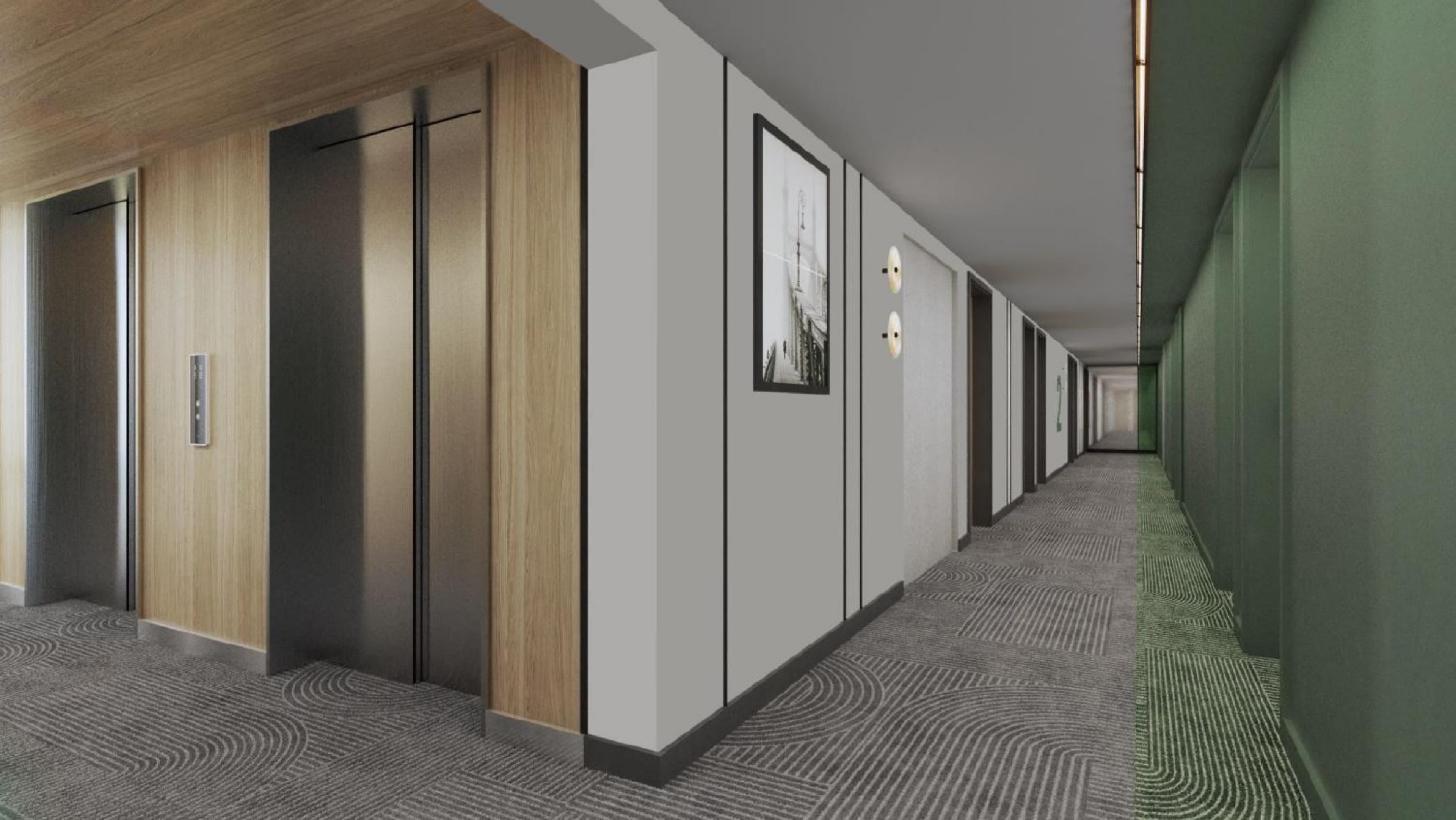 A hotel corridor with a carpeted floor, wooden panel walls, and a green accent wall.