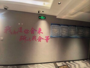 A wall with a sign indicating an exit and several informational posters.