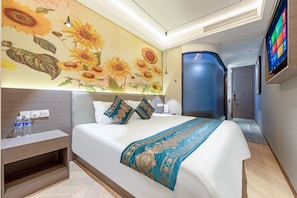 A hotel room with a bed, a nightstand, a wall-mounted TV, and a door leading to another room. - JINOUWANGUO HOTEL (Huangpu District)