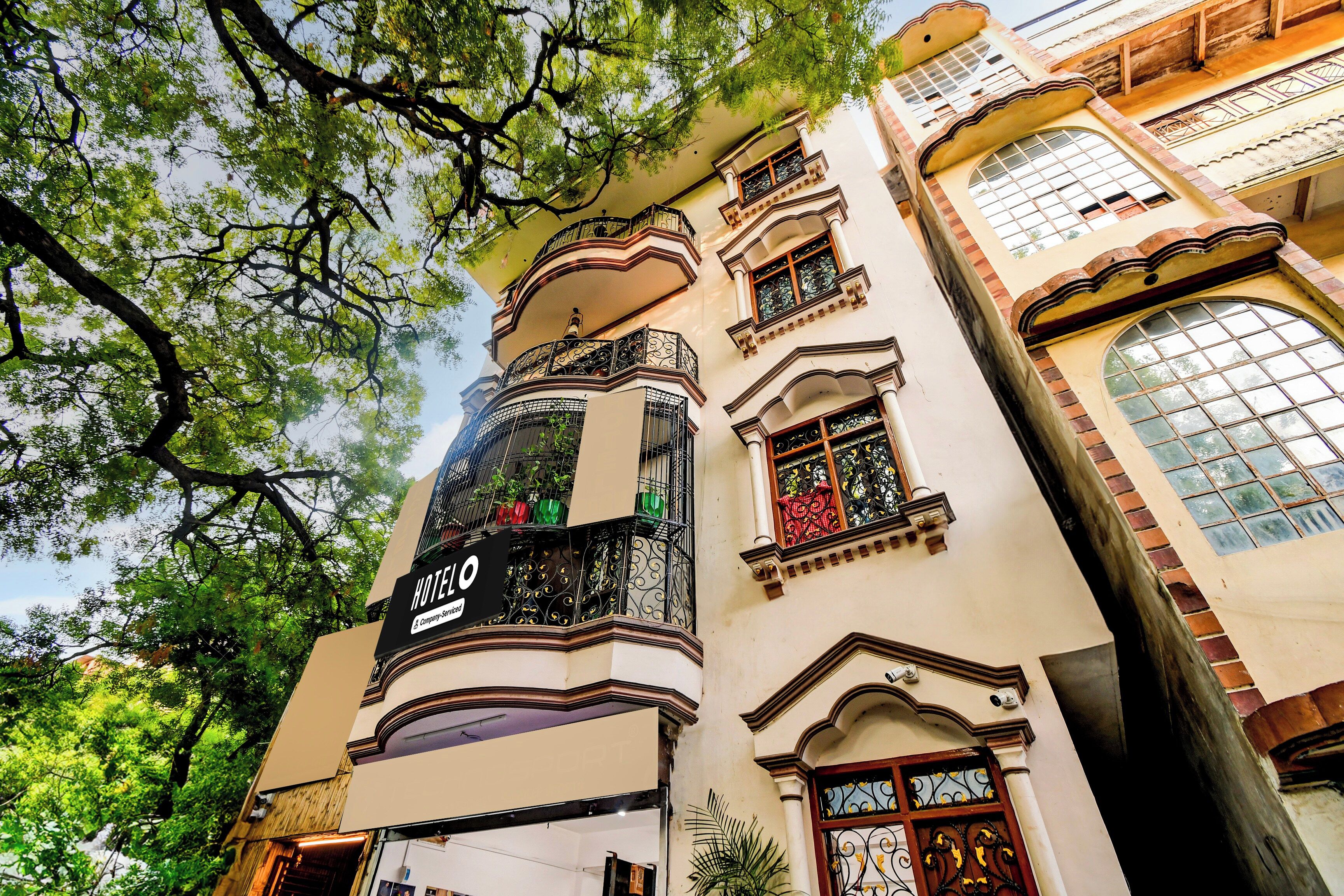 Um hotel com uma placa grande de 'HOTEL', varandas elaboradas e janelas amplas.