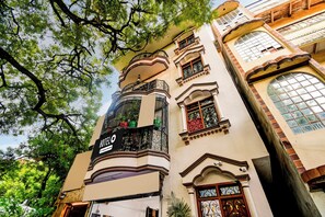 Um hotel com uma placa grande de 'HOTEL', varandas elaboradas e janelas amplas.