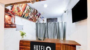 Un comptoir de réception d’hôtel avec une pancarte indiquant qu’il est géré par l’entreprise.