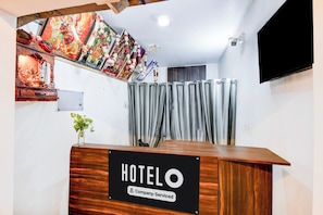 A hotel reception desk with a sign indicating it is company-serviced. - Hotel O Benia Park Formerly Parv (Varanasi)