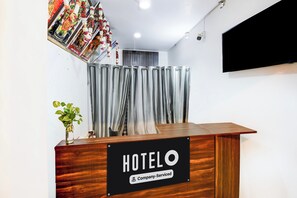 A hotel reception desk with a sign indicating it is company-serviced. - Hotel O Benia Park Formerly Parv (Varanasi)