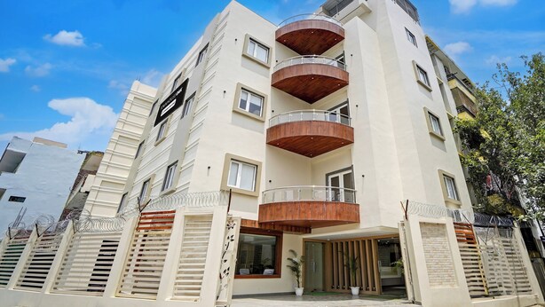 Un immeuble à plusieurs étages doté d’une cour intérieure, de balcons et d’une enseigne indiquant qu’il s’agit d’une maison de ville.