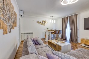 A modern living room with a sectional sofa, a coffee table, and a dining area with bar stools. - Wonderful pet-friendly 2-bedroom apartment with AC in quaint Pazin (Pazin)
